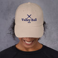 Valley Ball 818 Cream Classic Hat with navy crossed bats, worn